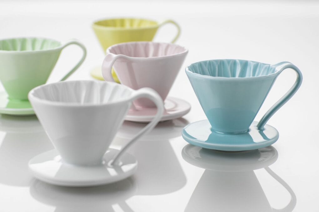 Cafec Flower Dripper Flower Dripper merkezden dışarıya su sirkülasyonu sağlayıp filtreleme yapacak şekilde tasarlanmıştır. Fincana istenmeyen tatların geçmesini önlemek için hızlı ve pürüzsüz su akışı gereklidir. Bunu sağlamak için uzun süren araştırmalardan sonra Cafec, dripper içinde gördüğünüz çiçek şekilli ideal tasarıma ulaşmıştır! Flower Dripper adını bu tasarımdan alıyor. Bu dizayn sayesinde döküş ve çıkış arasındaki su akış oranları eşit tutulabilir ve suyun dripper içinde birikmesine engel olunur. Doğru demlemeye estetik biçimde ulaşmanın en zarif yolu!  Stabil, hızlı ve dengeli demlemer için Flower Dripper’ınızı tüm Cafec filtrelerimiz ile kullanabilirsiniz. Cafec Flower Dripper özellikleri Tek Delik Tabanın merkezinde yer alan tek ve büyük çıkış deliği derin bir filtreleme ve hızlı çıkış sağlar. Konik Şekil Konik şekilli tasarım derin bir filtreleme ve suyun dripper içinde sirkülasyonuna imkan sağlar. Bu sayede su tüm kahve partiküllerine yayılır ve kahveden almak istediğimiz gövde çıkarılırken pürüzsüz de bir sonuç elde edilir. Taban Tasarımı Taban deliği hatları kahve için tutarlı çıkış patikaları yaratarak dengeli bir akış ve fincan sonuçları sağlar. Arita Ware Nedir?  Arita Ware 400 yıllık tarihe sahip özel bir Japon porselenidir. Yüksek kaliteli porselen hamuru ve taş tozuyla bir karışım elde edilir ve bu karışım 1.300C sıcaklıkta işlenir. Sonuç mineral kadar sert olmasına rağmen zarif bir dokudur. Arita Ware tüm dünyada beğenilen en kaliteli Japon geleneksel porselenidir. Cafec Flower Dripper Cup yeşil